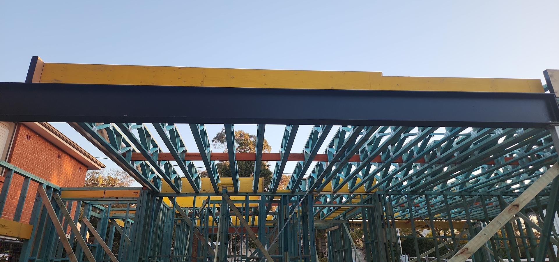 Treated pine roof trusses and wall frames under a steel beam and LVL beams