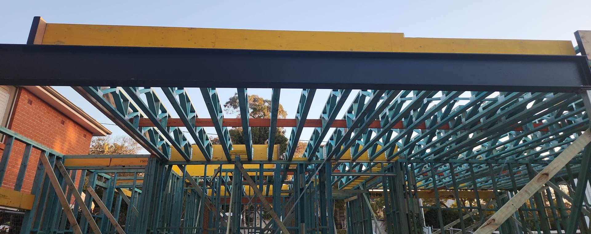 Treated pine roof trusses and wall frames under a steel beam and LVL beams