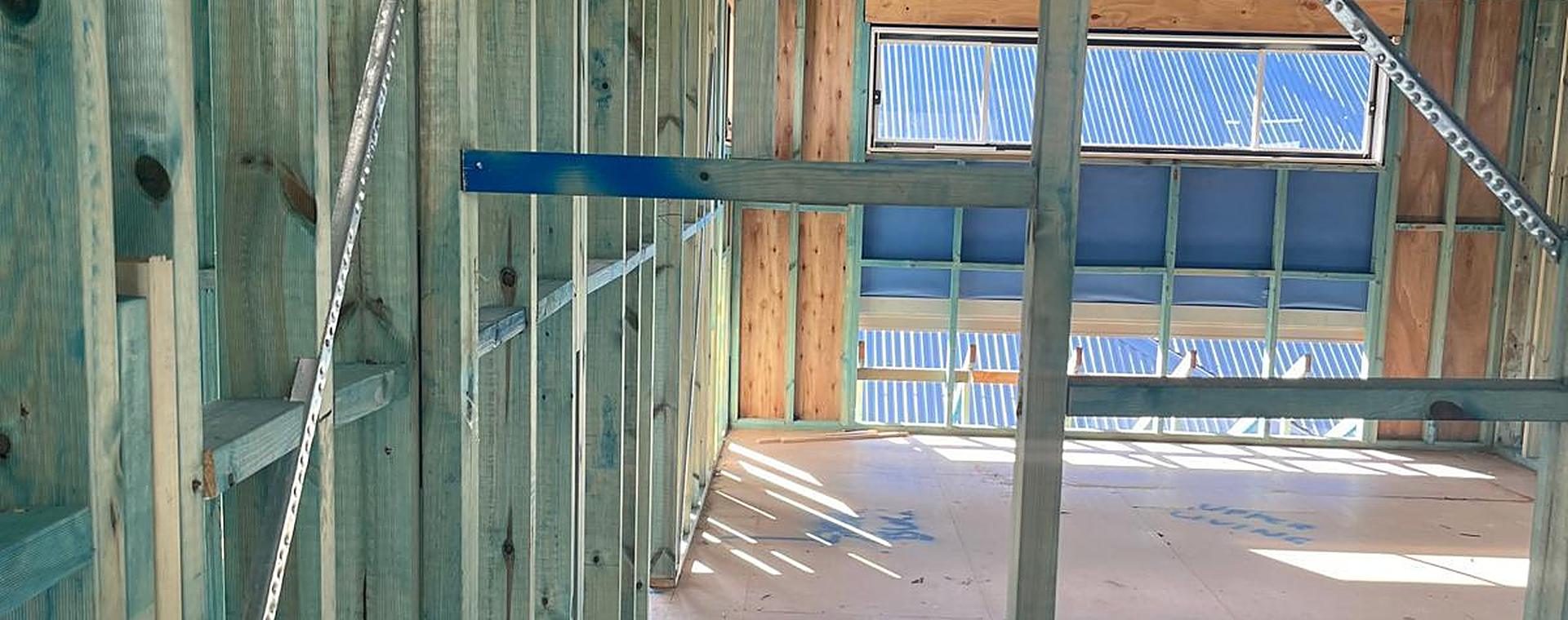 Inside an upper storey: wall frames, strap bracing and flooring sheets